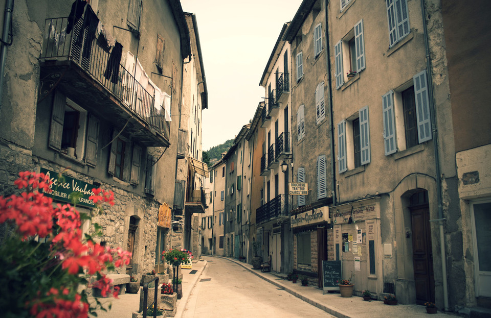 A narrow stone street lined with flowers